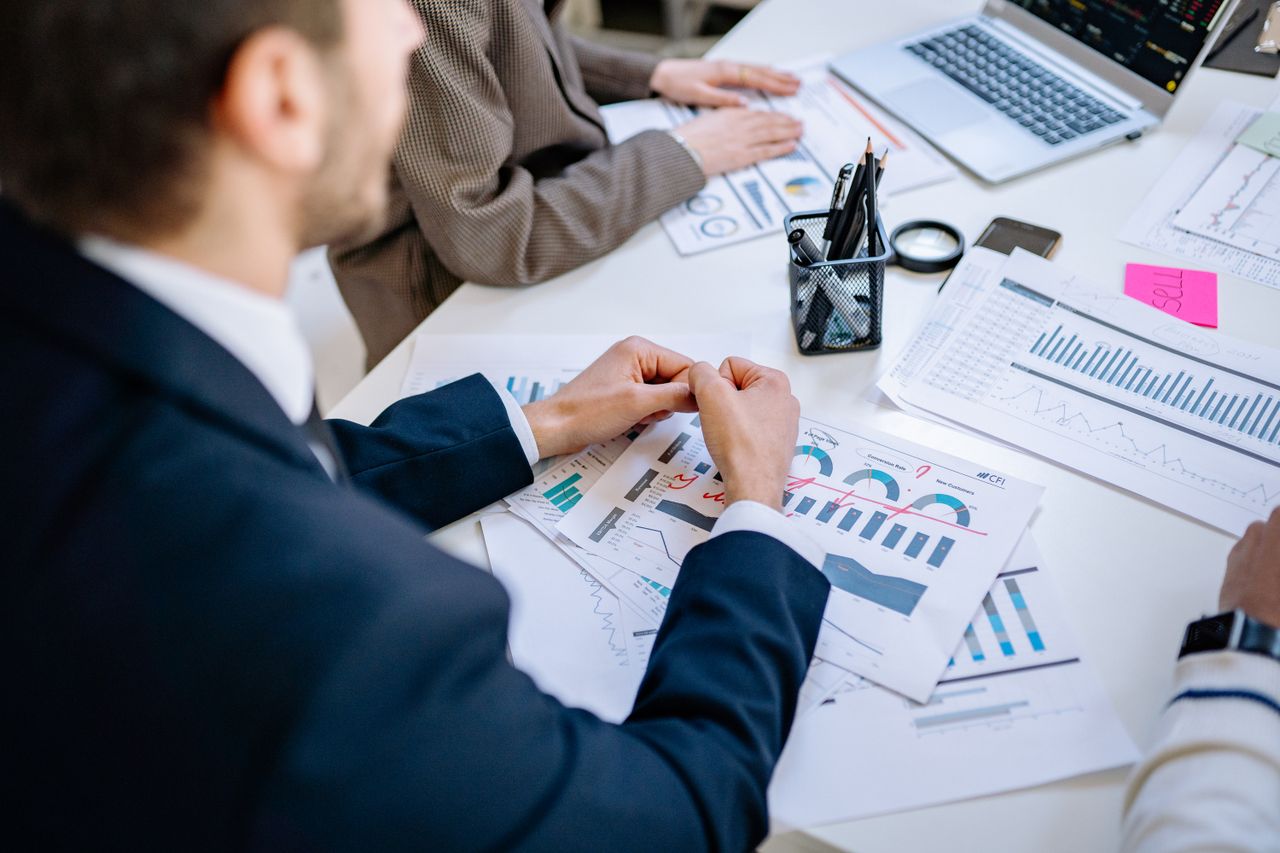 about-01 Business team analyzing financial graphs at a meeting table, fostering collaboration in an office environment.