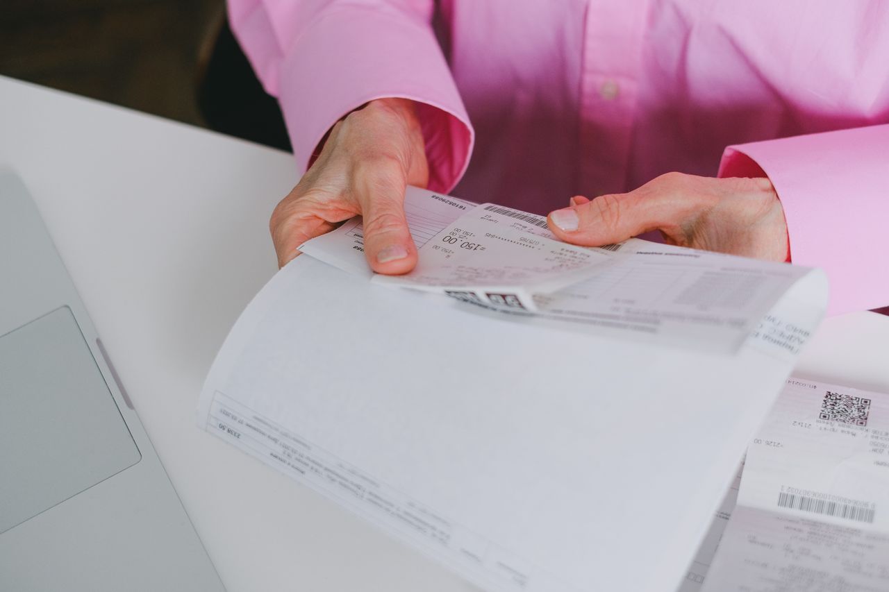 gallery-5 Business person handling paper receipts, meticulously organized.